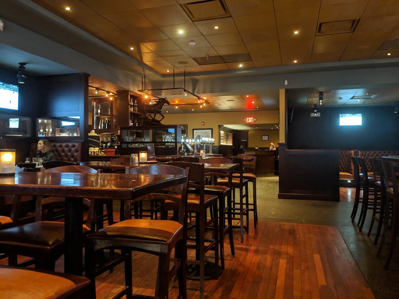 Inside The Bedminster Tavern: high-top tables, warm light, and the bar beyond.